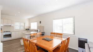 Enjoy cooking in the fully equipped kitchenette with microwave, stove, and oven, and dine at the central dining table with six chairs.