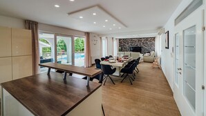 Eine moderne Küche mit Holzarbeitsplatte, Essbereich mit Stühlen und einer Couch.