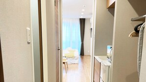 A hallway leading to a bedroom with a bed, a desk, and a chair. - HOTEL CLA-SS HIROSHIMA - Dobashi (Hiroshima)