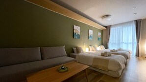 A modern hotel room with a sofa, two beds, a wooden coffee table, and artwork on the walls. - HOTEL CLA-SS HIROSHIMA - Dobashi (Hiroshima)