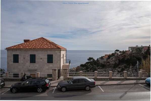 A building with a tiled roof, a staircase, and a view of the sea. - Apartment Pulastar (Dubrovnik)