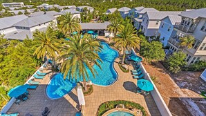 A resort with a large swimming pool, lounge areas, and multiple buildings with balconies.