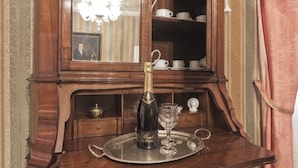 A wooden cabinet with a mirror, a bottle of champagne, and a glass on a tray. - Deluxe Venetian Apartment at Rialto (Venezia)