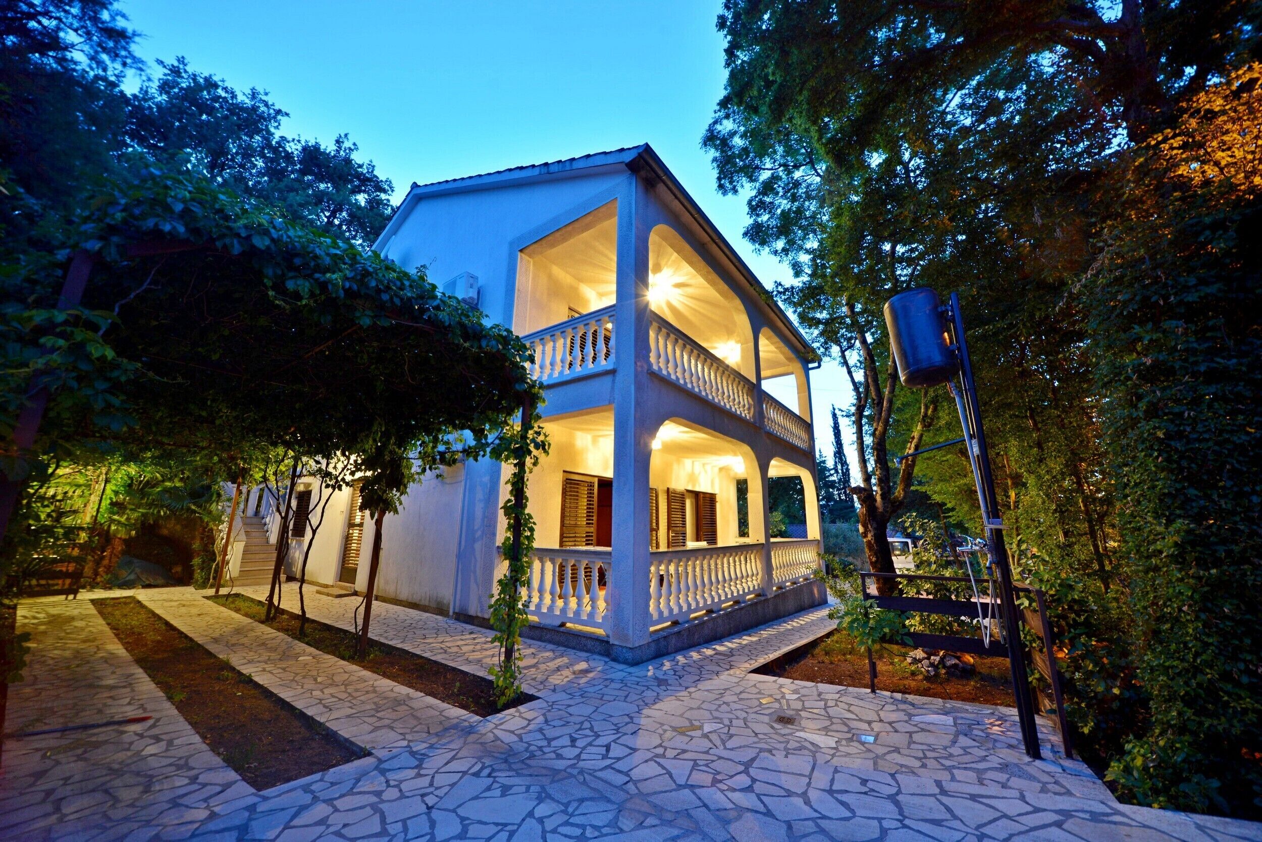 A two-story building with a balcony and a stone-paved entrance.