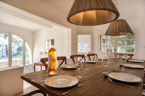A dining table set for six with plates, glasses, and cutlery, a bottle of wine, and a lamp above. - Exclusive flat with panoramic view (AC everywhere) (Saint-Paul-De-Vence)