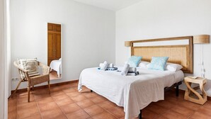 Une chambre d’hôtel avec un lit, une chaise, une table de chevet et une lampe.