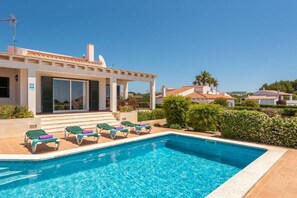 A modern villa with a swimming pool, sun loungers, and a covered patio area. - Villa Poppy. Private pool, Full AC & Wifi, Menorca (Sant Lluís)