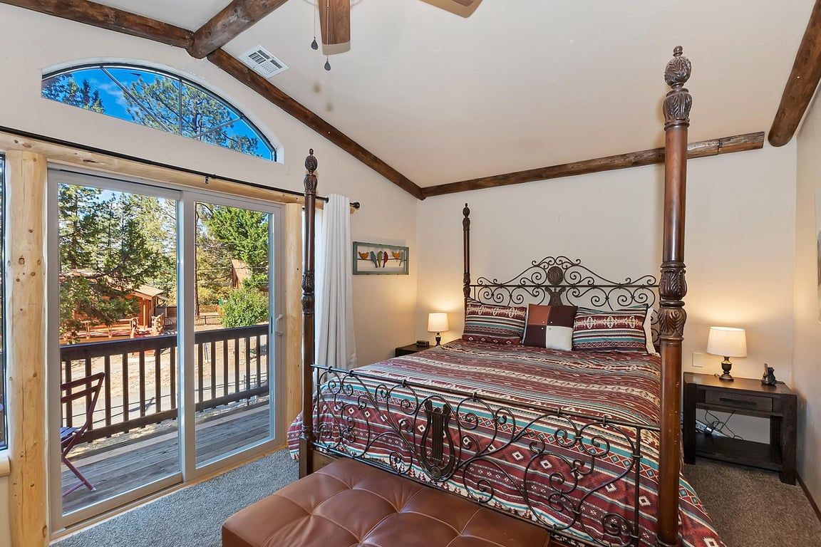 Una camera da letto con un letto a baldacchino, una grande finestra e un balcone.