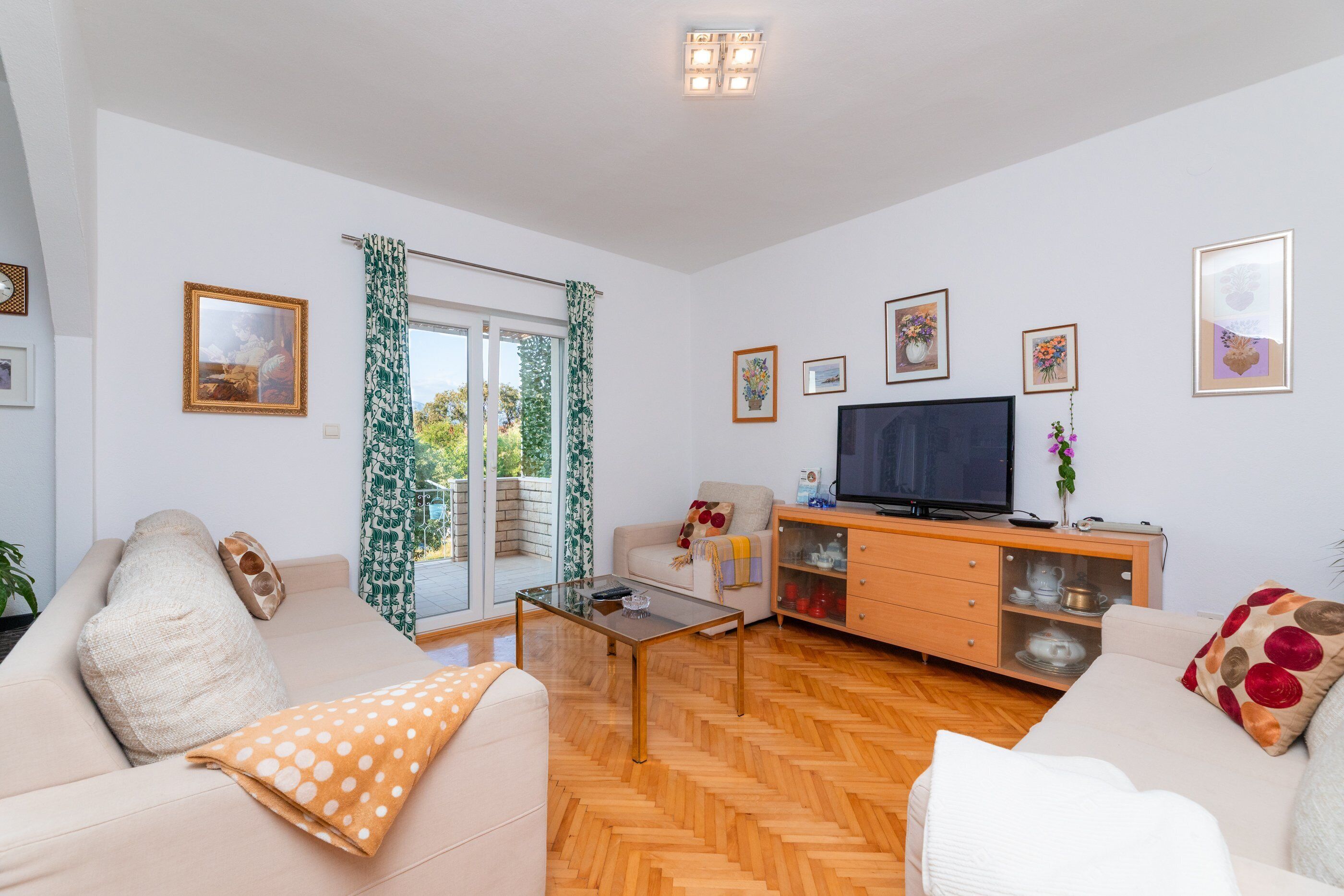 Amplia sala de estar con un sofá, una mesa de centro, un televisor y un mueble.
