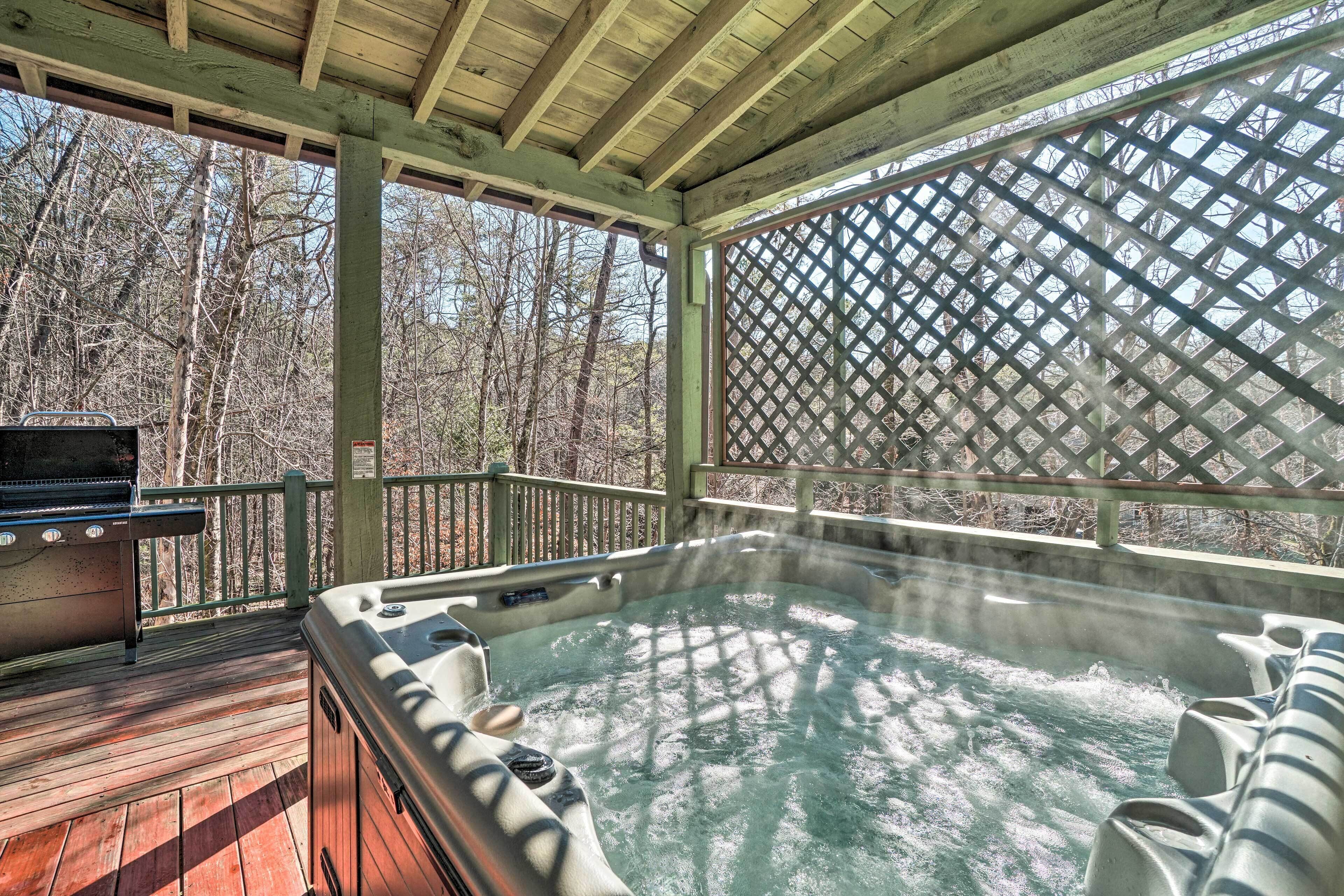 A hot tub on a wooden deck with a view of a forest.