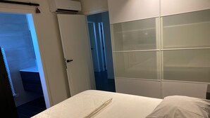 A hotel room with a bed, a wardrobe, and a door leading to a bathroom. - La Cigale, beautiful villa with infinity pool and breathtaking views  (Chassagnes)
