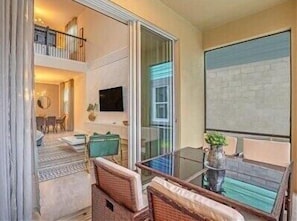 Relax in a spacious room with a comfortable seating area, dining space, and a mounted TV.