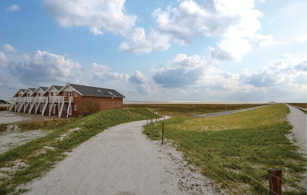 A building with multiple rooms, a gravel path, and a grassy field. - 1 bedroom amazing apartment in Rømø (Rømø)