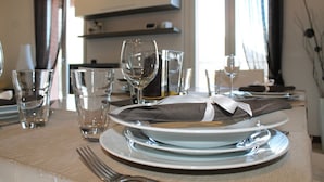 Una mesa de comedor dispuesta con platos, vasos y cubiertos.