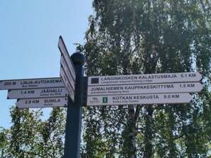 A directional signpost with multiple destinations and distances.