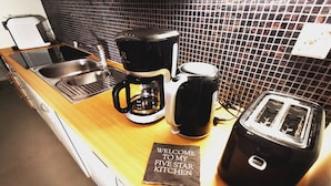 A kitchen counter with a coffee maker, toaster, and a welcome sign.