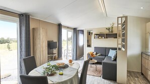 Een moderne woonkamer met een eetgedeelte, een bank en een televisie.