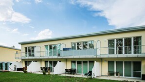 Ein zweistöckiges Gebäude mit großen Fenstern, einem Balkon und einer flachen Dachfläche.