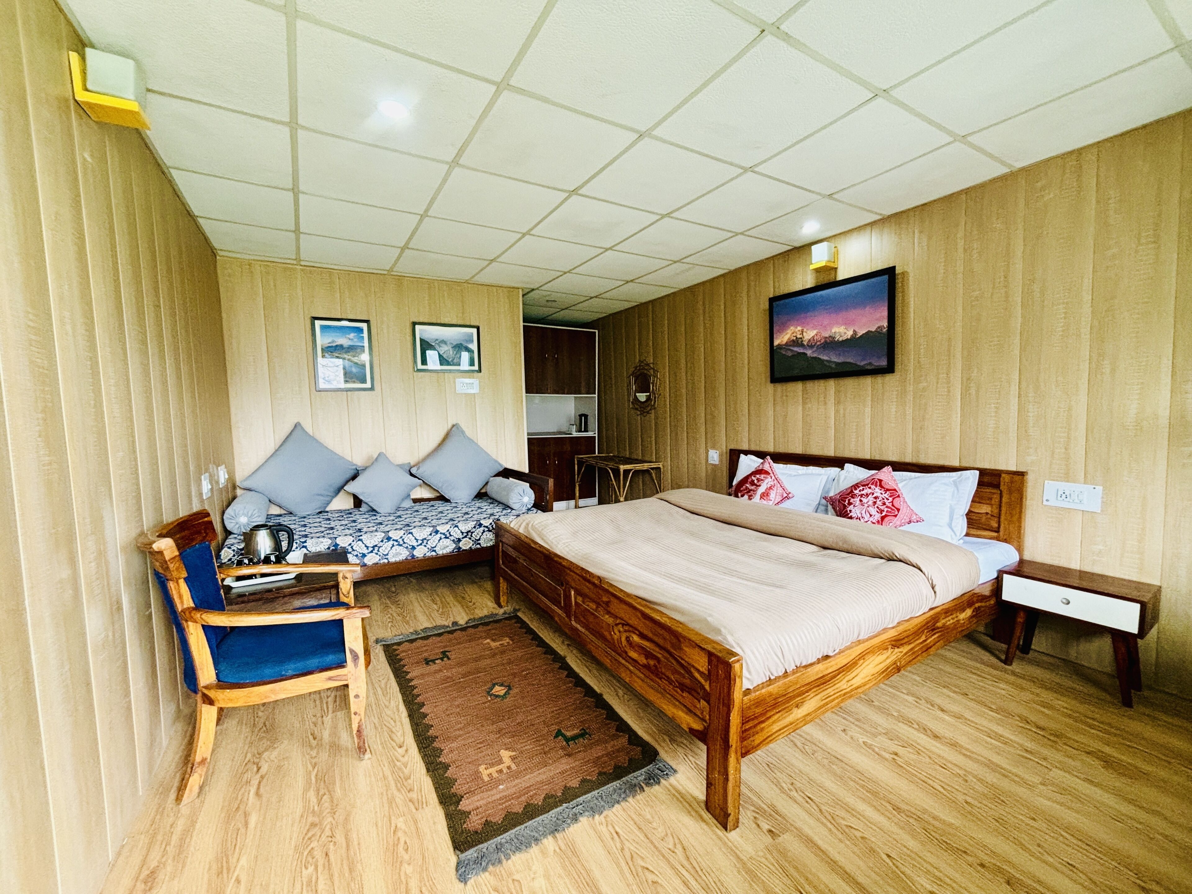 A room with a wooden bed, a sofa, a small table, and a rug.
