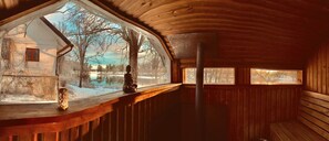 A wooden cabin with a large window overlooking a snowy landscape. - Romantic Spa Villa With Fireplace by the Lake (Stjärnsund)