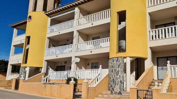 A multi-story hotel with balconies, a central staircase, and a distinctive tower-like structure.