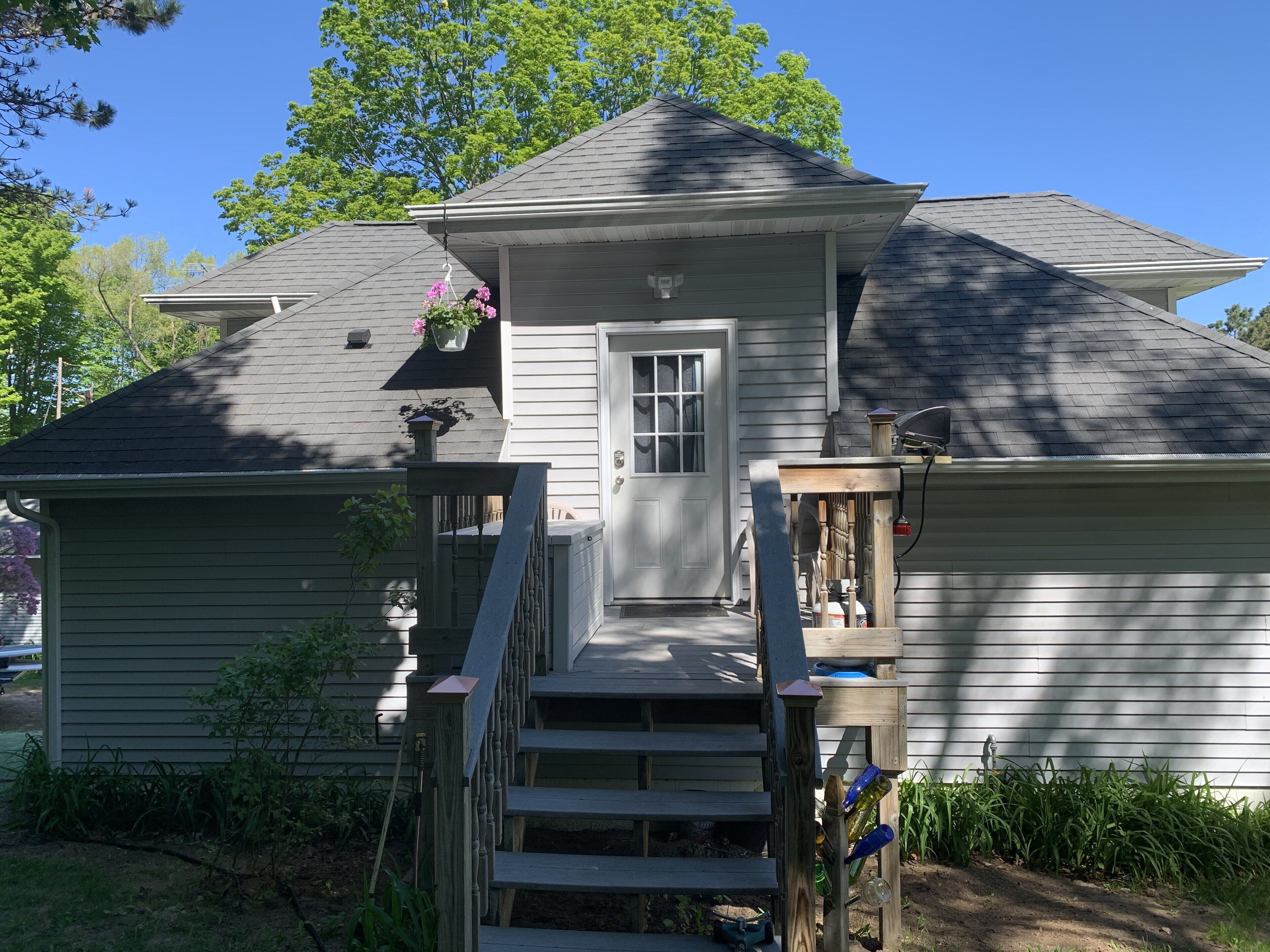 A house with a front porch, a door, and a small set of stairs leading to the entrance.