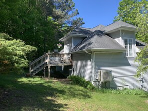 A two-story house with a covered porch and a small staircase leading to the entrance.