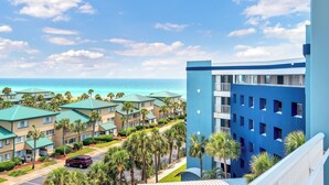 A hotel with multiple buildings, a parking area, and a view of the ocean. - Destin West G204 — Gulfside 2BR + Bunk Room, Sleeps 8 (Fort Walton Beach)