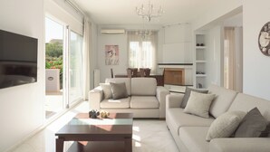 Un salon moderne avec un canapé, une table basse et un téléviseur à écran plat.