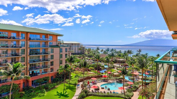 A resort with multiple floors, a swimming pool, and a view of the ocean.