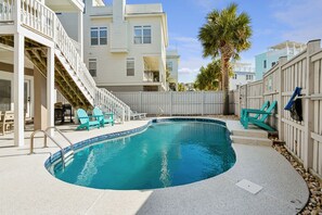 A swimming pool with a curved edge, surrounded by a white fence, and adjacent to a building with balconies. - 8BR Beach Oasis w/ Pool & Rooftop (Isle of Palms)