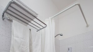 Une salle de bain avec une douche, des toilettes et un porte-serviettes.