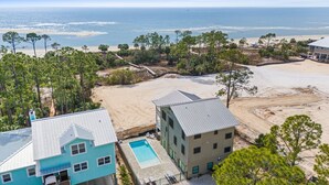 A beachfront property with a swimming pool, a beach, and a view of the ocean. - Redbird Beach: 7BR Beachfront Home- Priv. Pool, Pet Friendly, Sleeps 23! (Port St Joe)