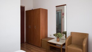 A room with a wooden wardrobe, a small table with a vase, and a chair. - Villa Konalić - Double or Twin Room with Balcony and Sea View 1 (Mokosica)