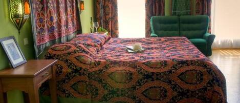 A room with a bed, a chair, a desk, and a lamp.