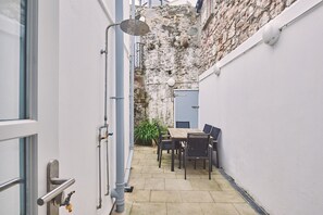 Enjoy dining or socializing in this charming outdoor space with a table and chairs.