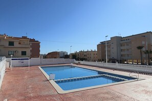 A rooftop swimming pool with a clear blue pool, surrounded by a white fence and buildings in the background. - 029 - Bochiot 001 - comfortHOLIDAYS (Santa Pola)