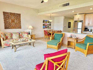 A living room with a sofa, chairs, a coffee table, and a dining area with a table and chairs.