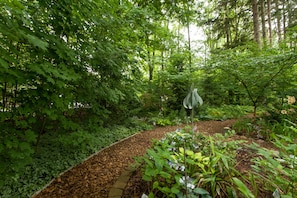 Stroll through a serene garden pathway surrounded by lush foliage and a variety of plants.