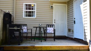 A porch with a wooden bench and chairs, a small table, and a grill. - Spacious Townhouse in the ❤ of Fayetteville (Fayetteville)