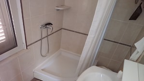 A small, clean bathroom with a shower, toilet, and sink. - Rooms Brezak - Double Room with Shared Kitchen (Lastovo)