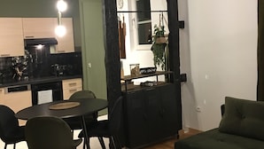 Un espace de vie compact comprenant un coin repas, un canapé et une cuisine.