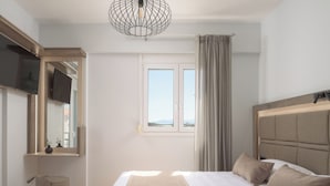 Une chambre à coucher moderne avec un grand lit, une table de chevet, un miroir et une fenêtre avec des rideaux.