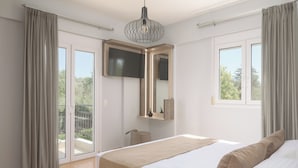 Une chambre à coucher avec un lit, un téléviseur fixé au mur et un balcon avec des rideaux.