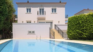 Un bâtiment à deux étages avec une piscine devant.