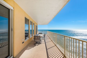 Enjoy the ocean view from this balcony with a comfortable seating area.