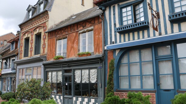Una hilera de edificios tradicionales de estilo europeo, con características arquitectónicas notables, como entramado de madera y vidrieras decorativas.