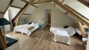 Una habitación con dos camas, vigas de madera y una ventana.