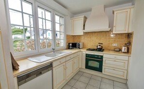 Enjoy cooking in this well-equipped kitchen with a double sink, microwave, gas stove, and dishwasher.