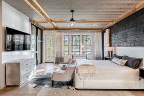 Un dormitorio moderno con una cama grande, un escritorio y un televisor.